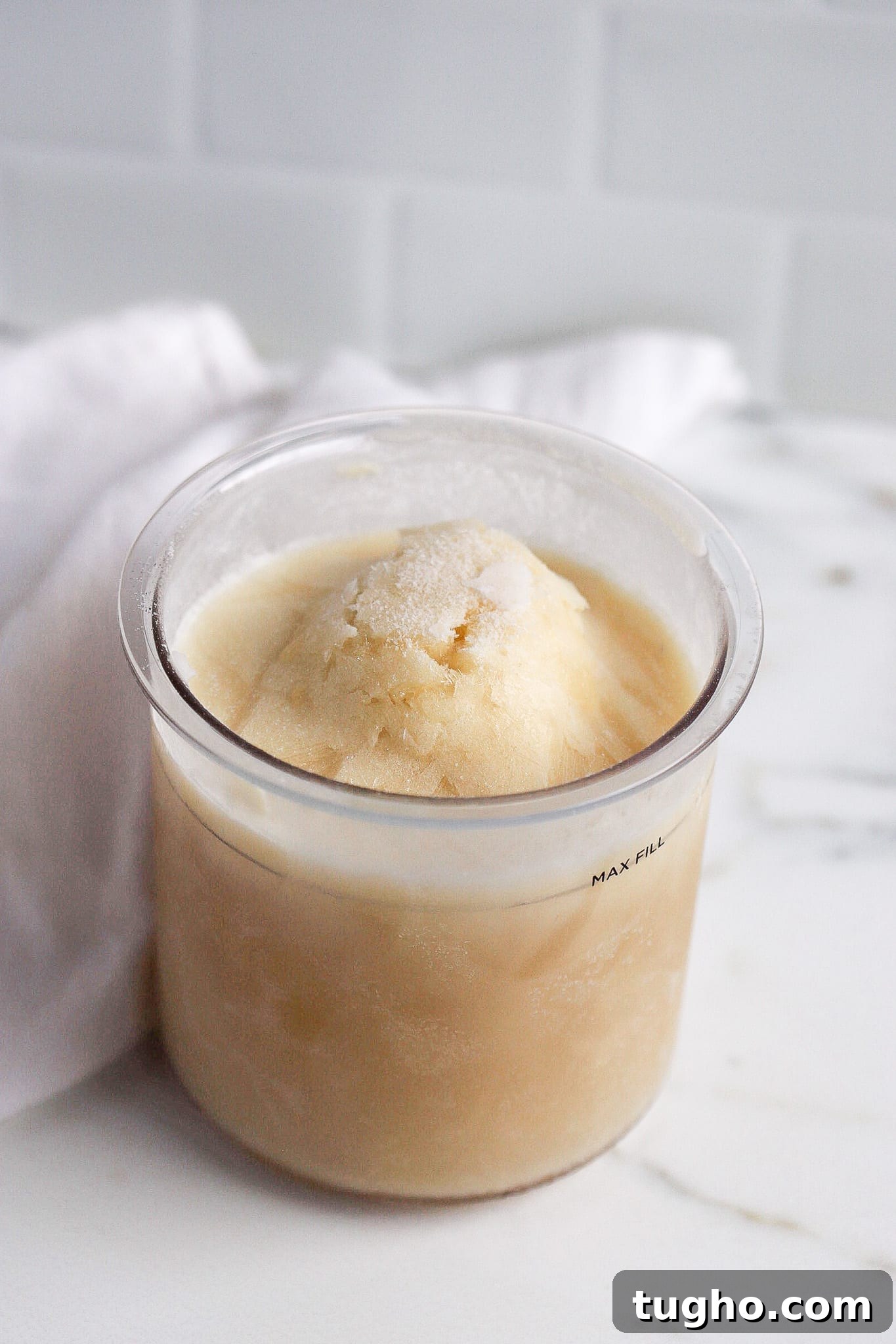 How to Make Vanilla Protein Ice Cream in a Ninja Creami 4 pint of frozen ice cream in the ninja creami container in white kitchen