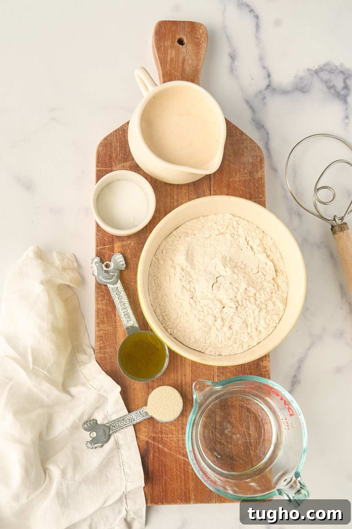How to Make Crusty Italian Sourdough Rolls 3 Ingredients measured in bowls on wooden board