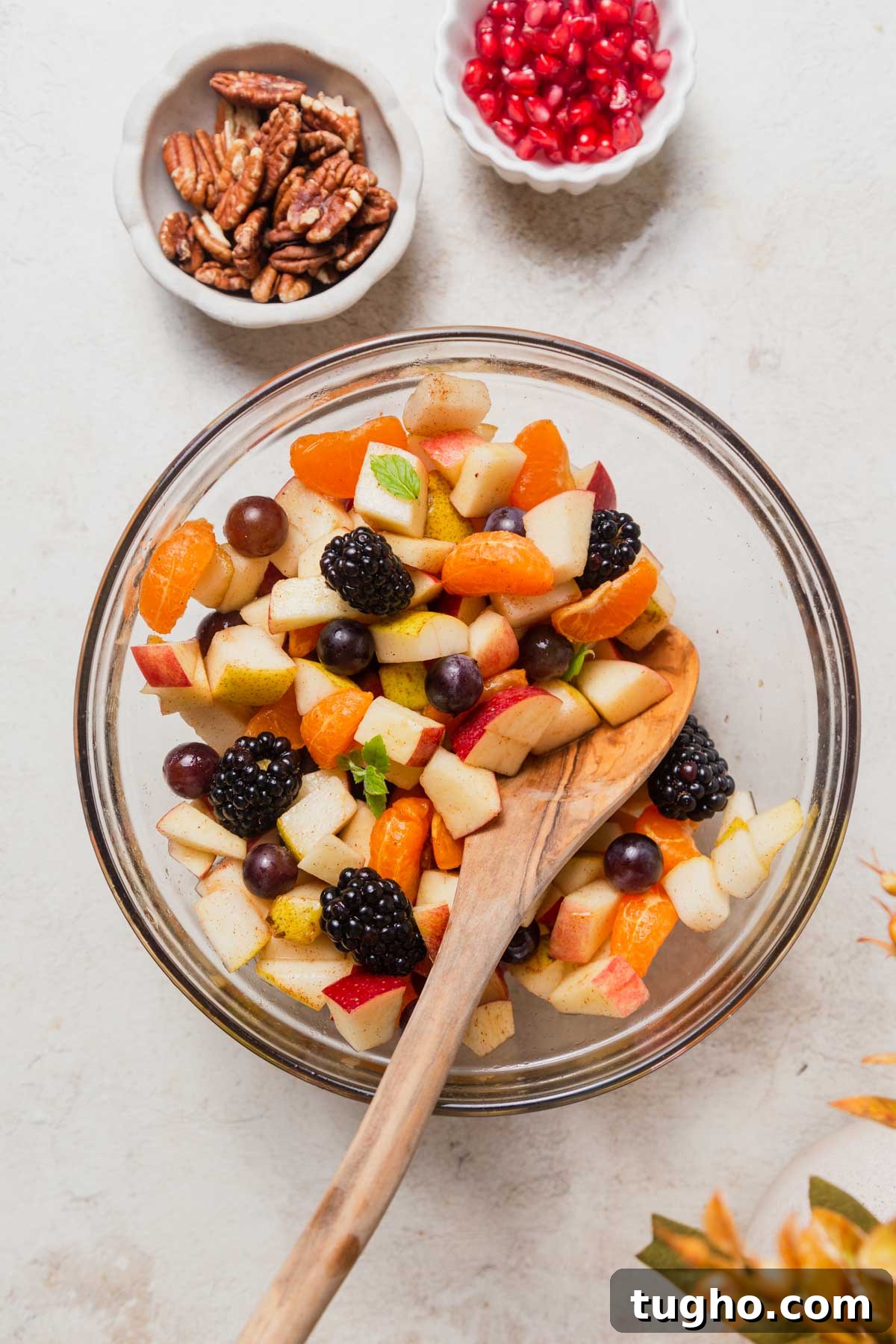 mixing the fall fruit salad.