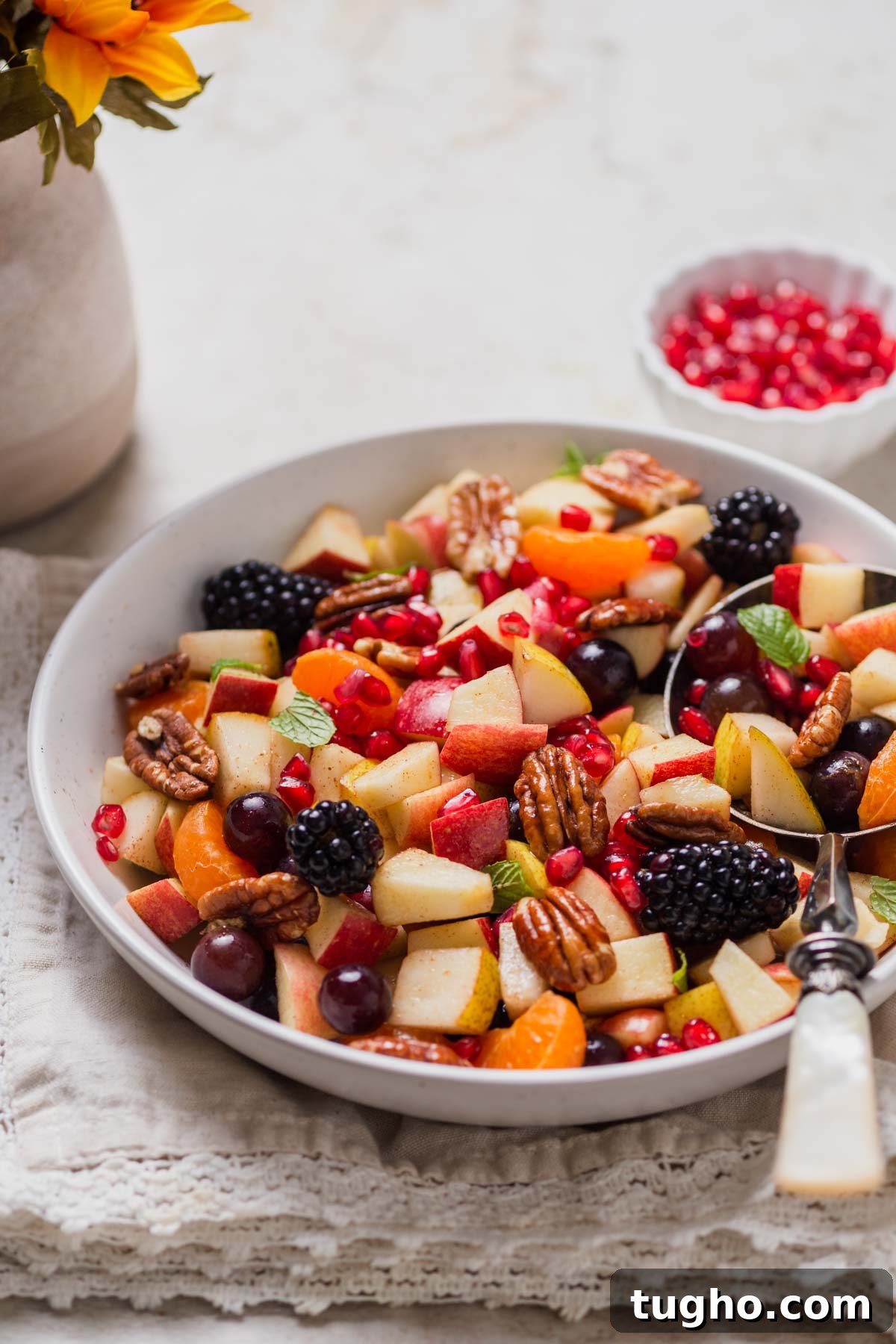 fall fruit salad on a bowl with a spoon with a napkin under it.