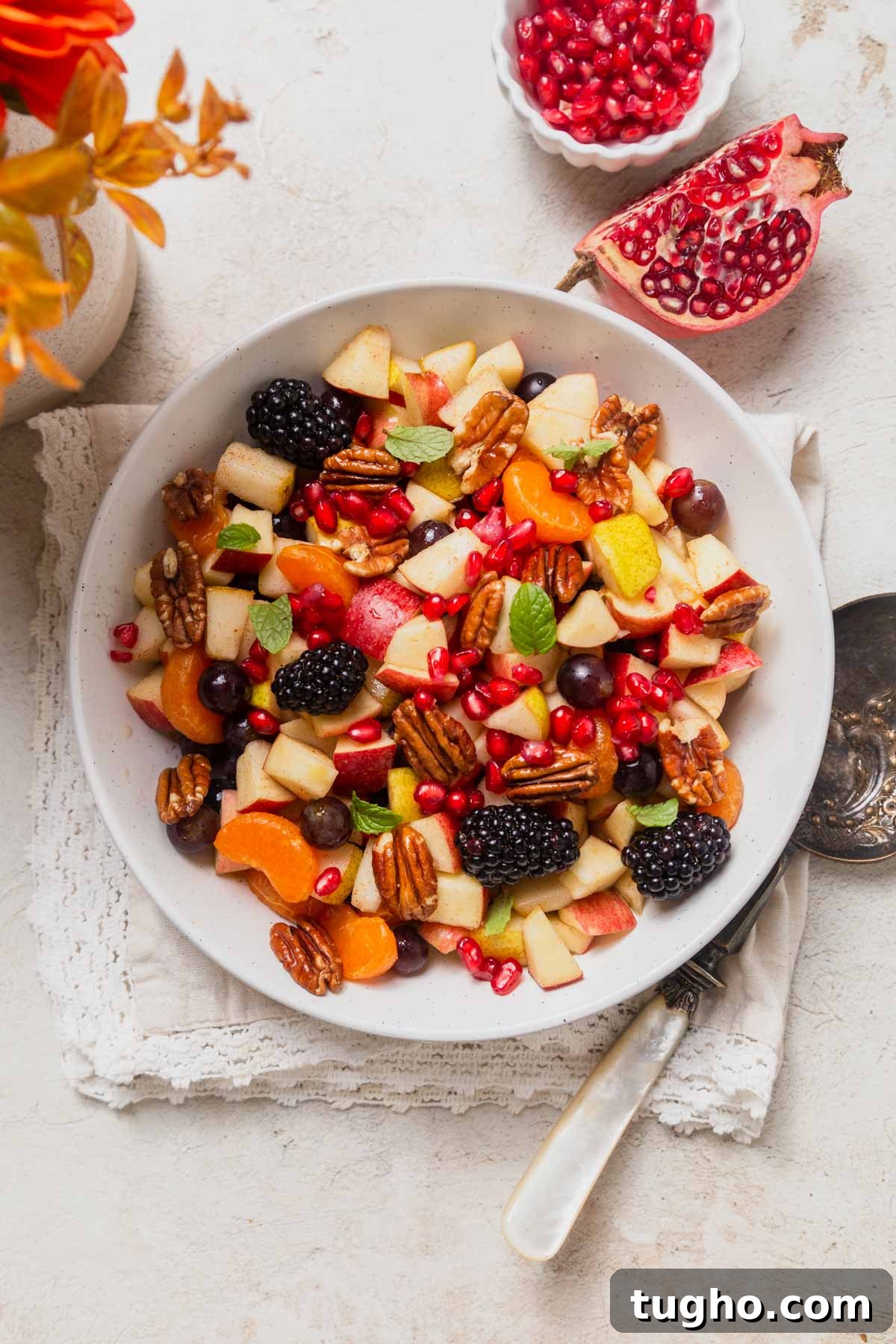 fall fruit salad on a bowl with pomegranate seeds on the side.