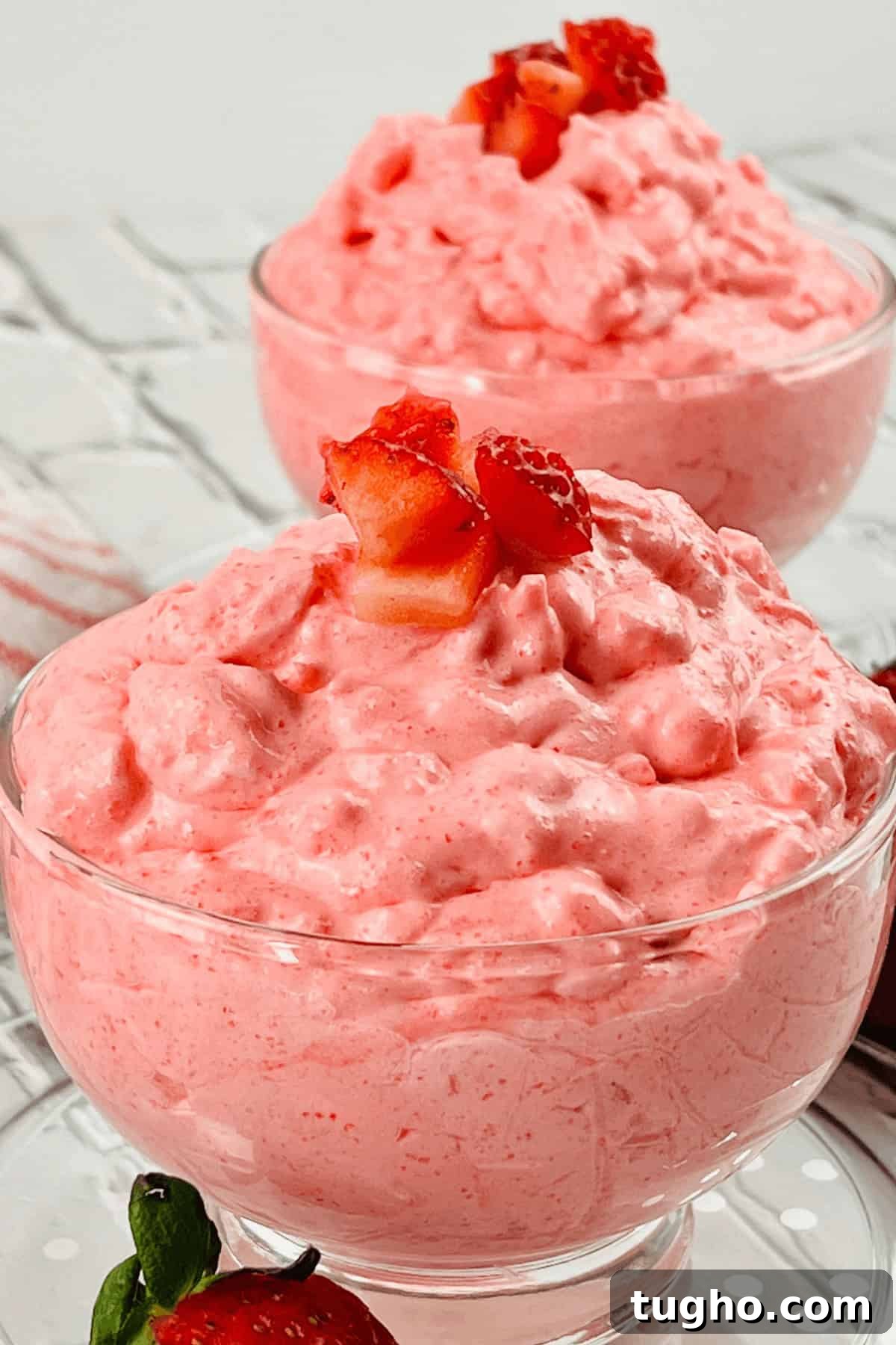 Two glass bowls filled with pink strawberry mousse, reminiscent of a delightful dessert.