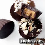 closeup of a homemade dark chocolate mini peanut butter cup with a bite taken out of it with title text overlay