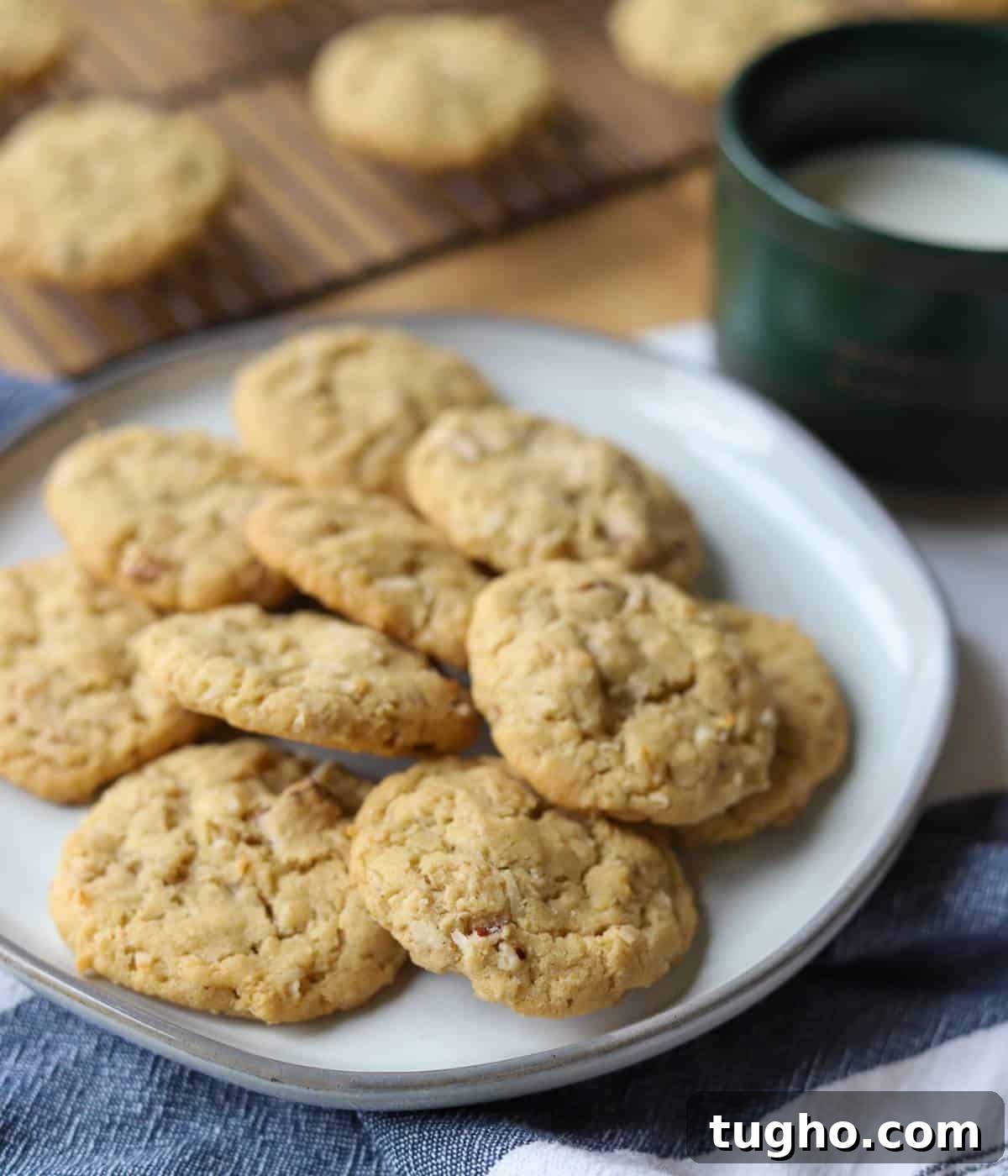 Coconut Pecan cookies on plate with coffee mug of milk.
