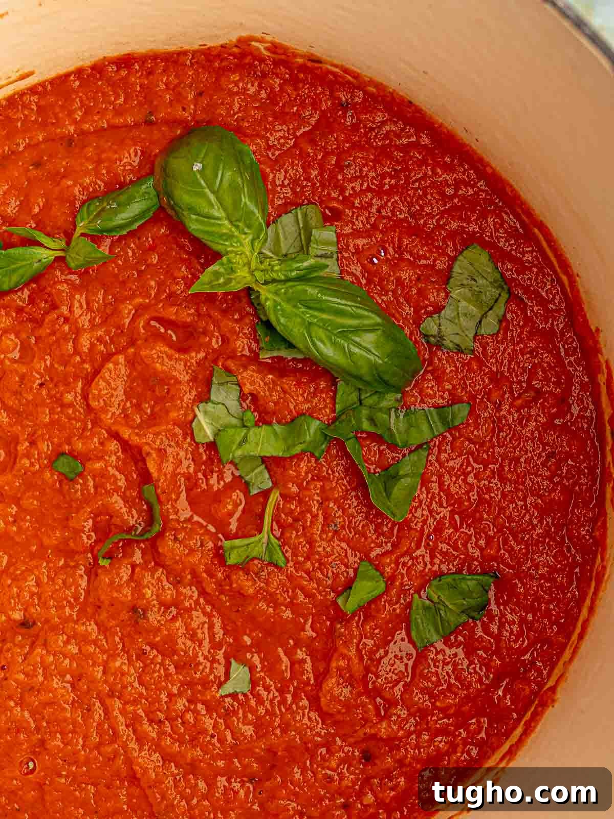 Nonna's Classic Italian Pasta Sauce Recipe 8 Italian tomato sauce in a pot with basil leaves.