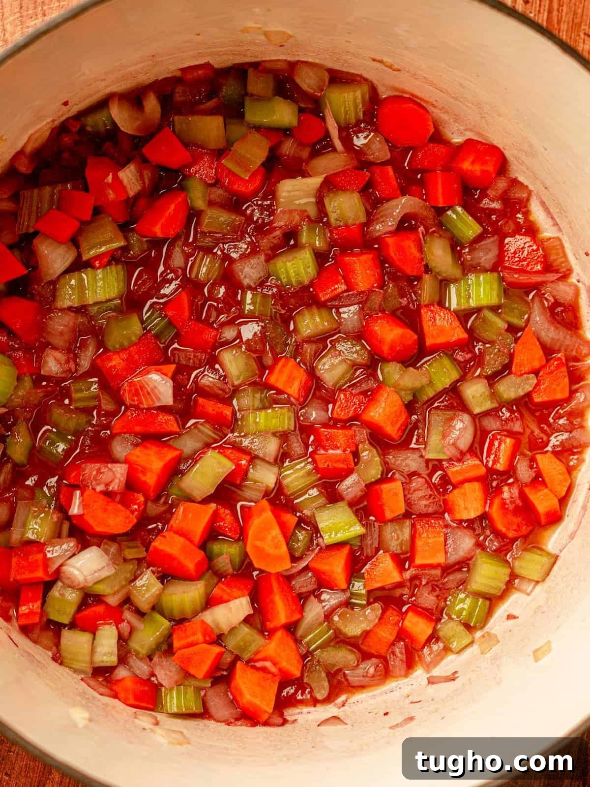 Nonna's Classic Italian Pasta Sauce Recipe 6 Onions, carrots and celery in a red wine broth in a pot.