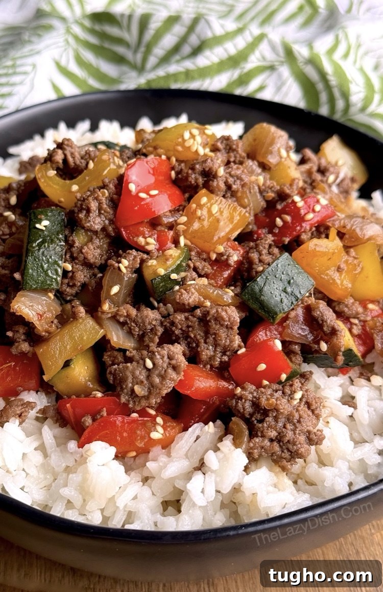 Beef and Pepper Rice Bowls 9 Close up view of a bowl of rice topped with a sweet and savory mixture of ground beef and bell peppers tossed in soy sauce and brown sugar sauce.