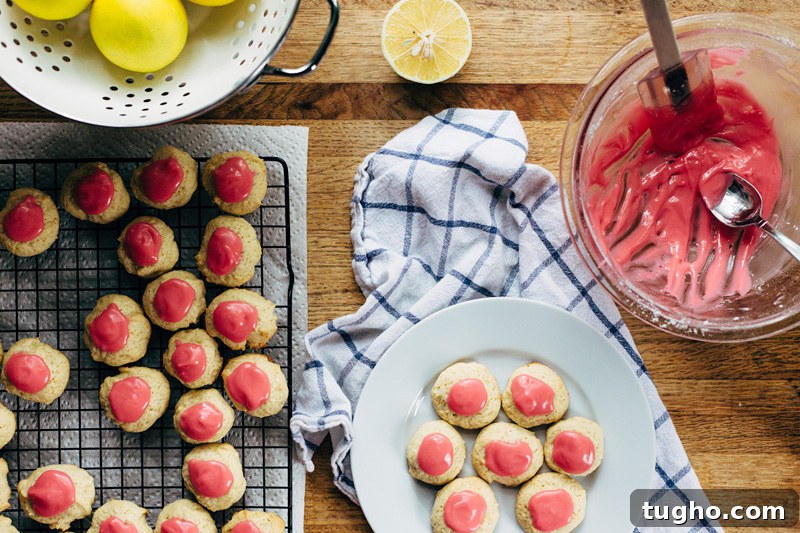 Zesty Lemon Buttermilk Cookies with Raspberry Glaze 2 buttermilk cookies being topped with a raspberry glaze