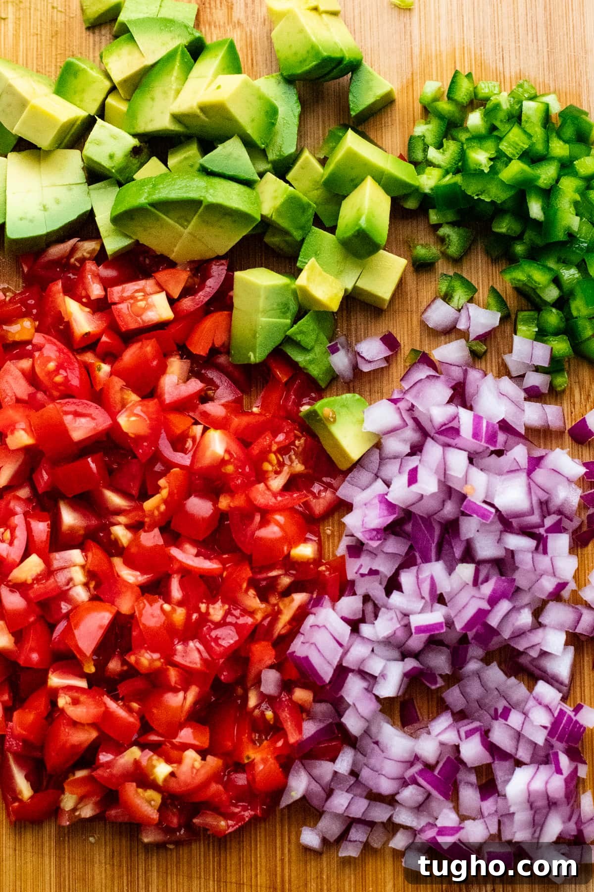 chopped vegetables for salsa arranged on wooden cutting board.