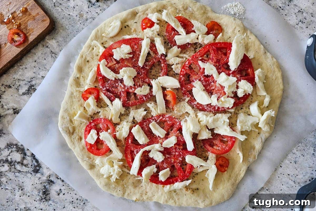 Pizza dough topped with mozzarella and fresh tomatoes.