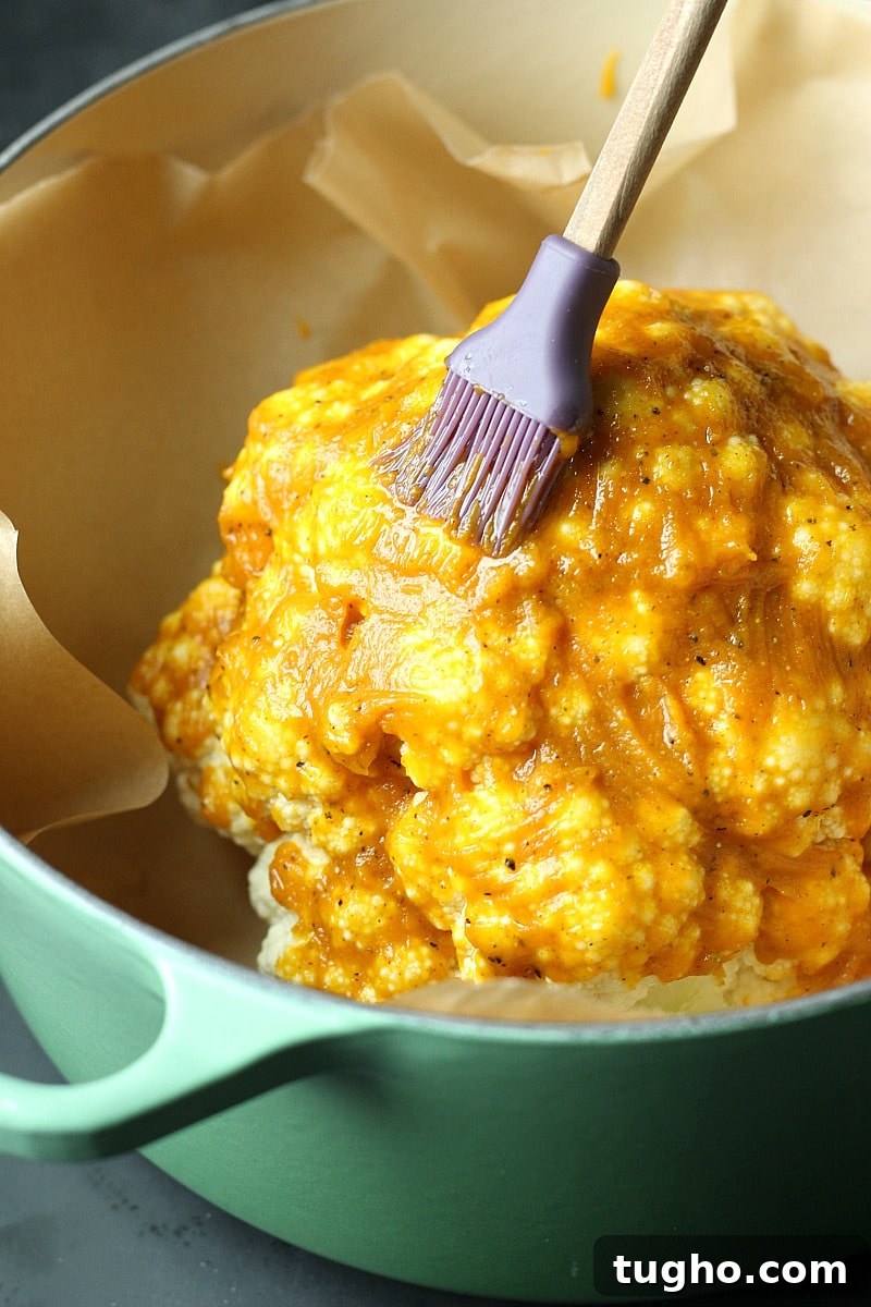 Crispy Pumpkin Spice Roasted Cauliflower Recipe 4 Cauliflower being brushed with pumpkin spice mixture, pastry brush, parchment paper.