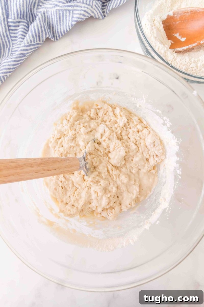 French Baguette Recipe: Make Two Loaves at Home 5 French bread ingredients being mixed into a wet dough in a mixing bowl – Hostess At Heart