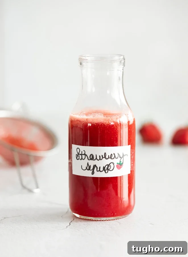 Homemade Strawberry Milk Recipe with Fresh Strawberries 9 A photo of strawberry syrup in a jar with a label titled strawberry syrup