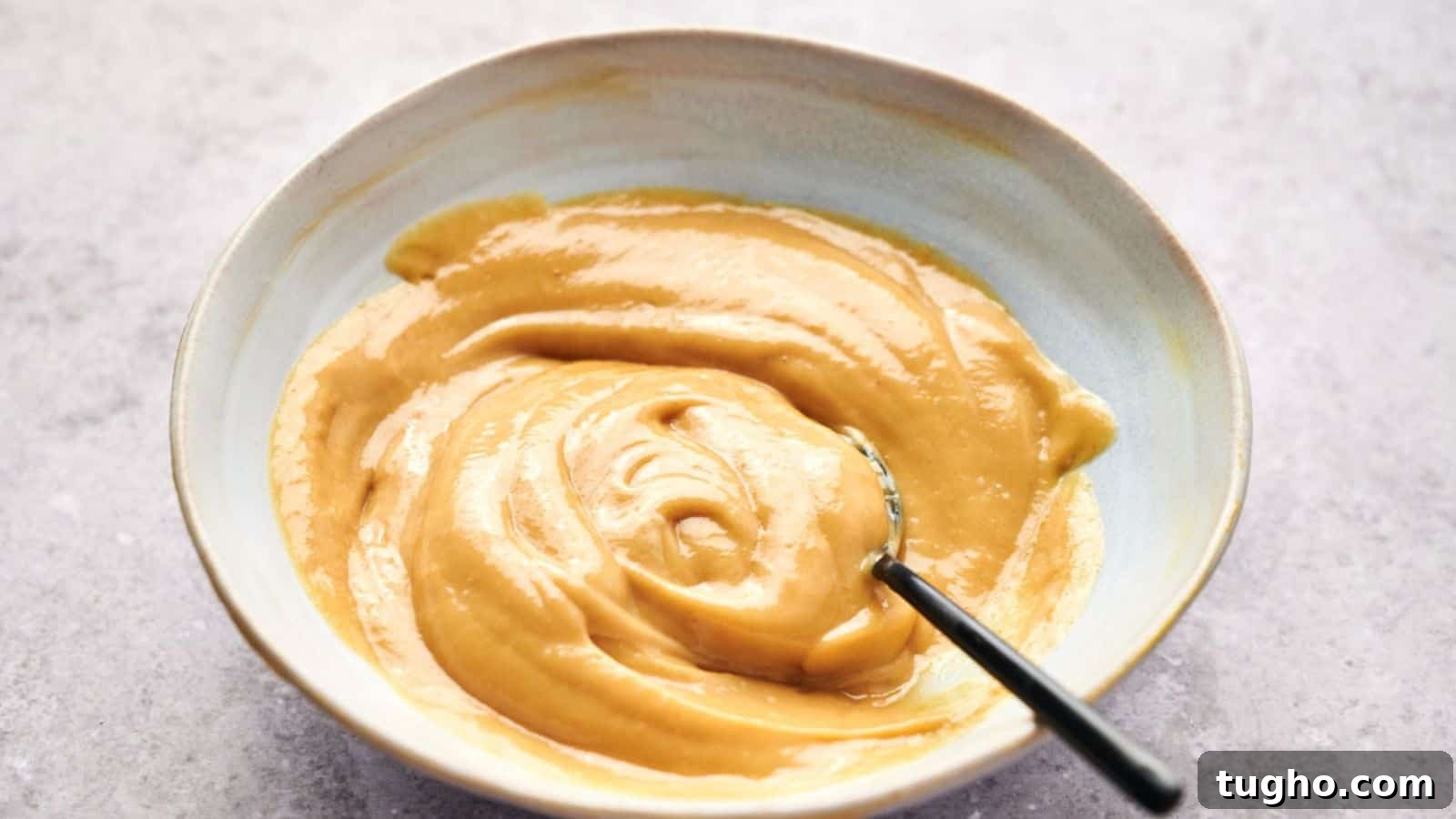 15 Copycat Recipes That Outshine Restaurant Meals 8 A bowl of smooth, creamy peanut butter with a hint of Chick-fil-A sauce and a spoon inside.