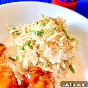 Creamy Creole Coleslaw Recipe with Zesty Remoulade 4 Creamy Creole Coleslaw on white plate with a side of chicken wings