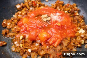 Leftover Turkey Curry with Coconut and Warm Spices 6 Chopped tomatoes, brown sugar, salt with chopped onions frying in a pan