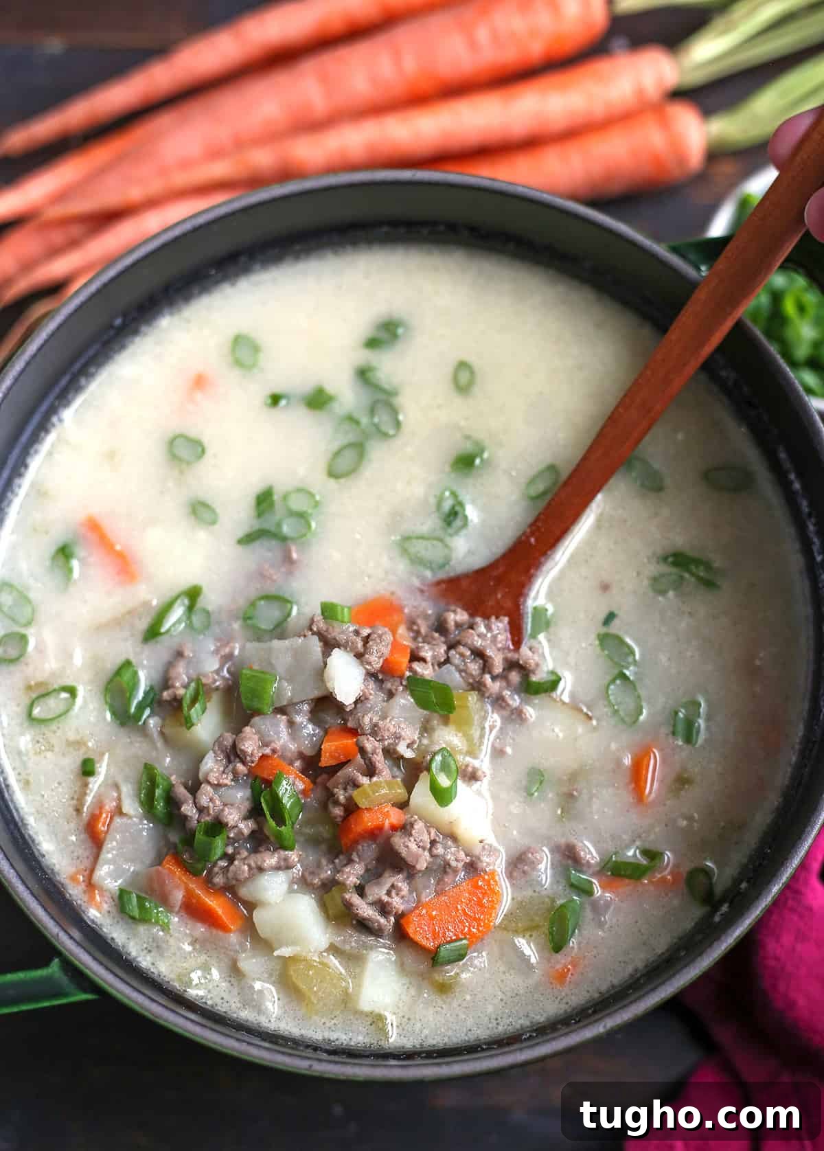 Creamy Cheeseburger Soup Recipe 4 A pot of cheeseburger soup with a spoon scooping a serving out.
