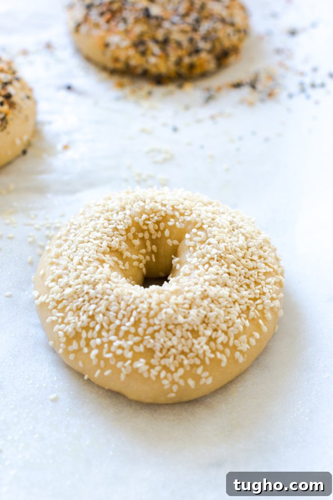 a sesame seed topped bagel before baking
