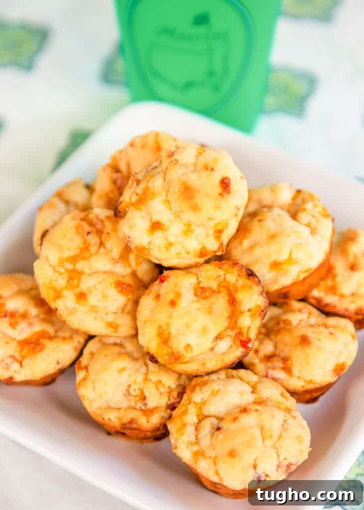 Pimento Cheese Muffins Recipe {The Masters} - pimento cheese baked into yummy muffins. Great as a snack, breakfast for with dinner. Bisquick, buttermilk, sugar and pimento cheese. Ready to eat in 10 minutes!! plate of pimento cheese biscuit muffins