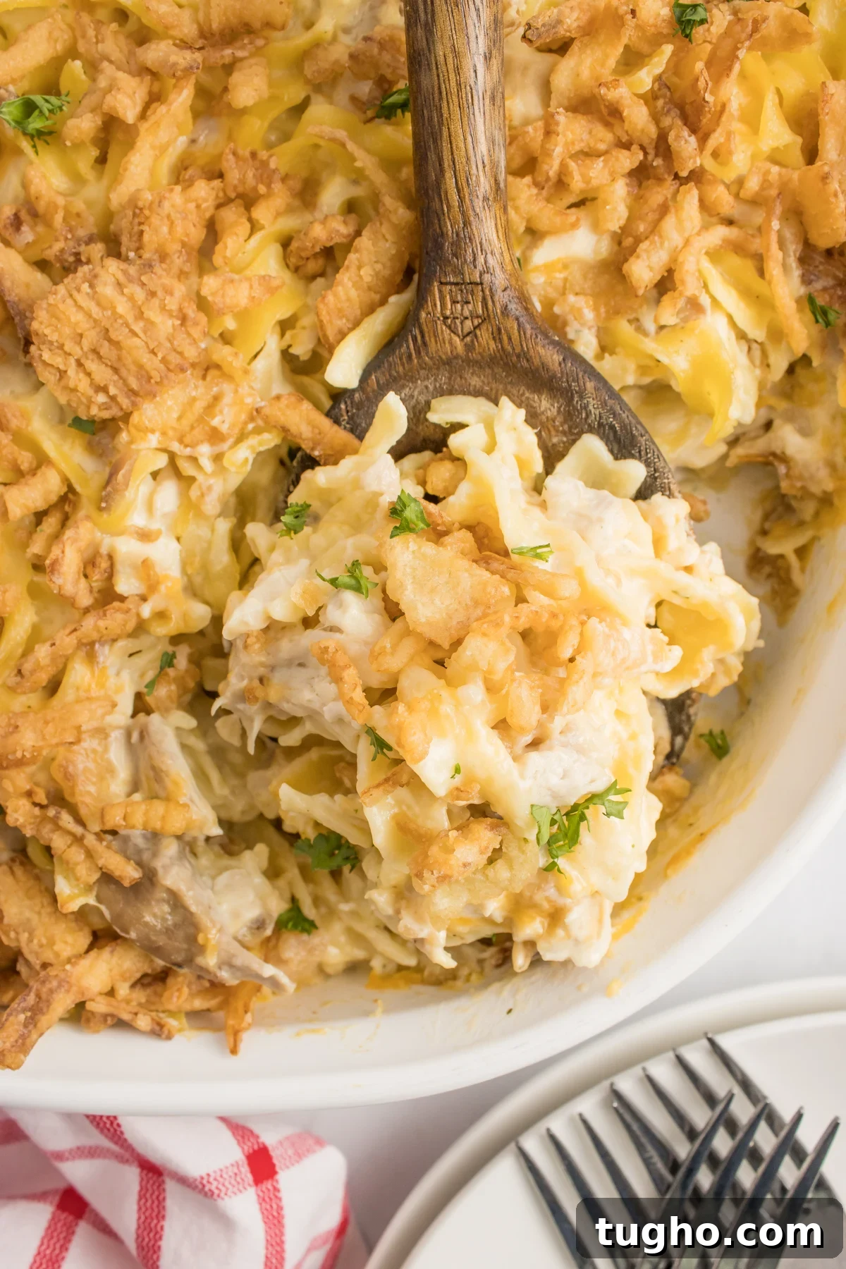 Creamy French Onion Chicken Casserole Recipe 6 A wooden spoon with a scoop of French onion casserole.