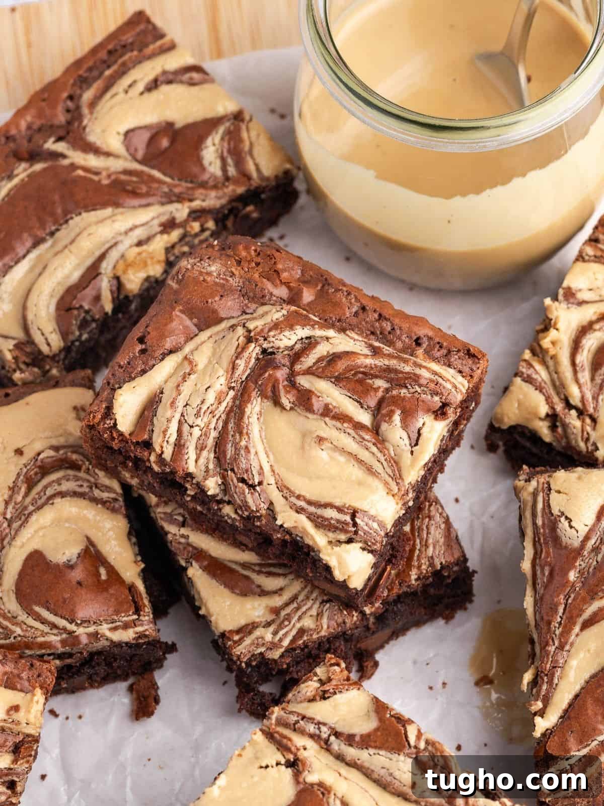 Fudgy Tahini Brownies with Nutty Chocolate Swirl 2 A stack of tahini brownies on parchment paper.