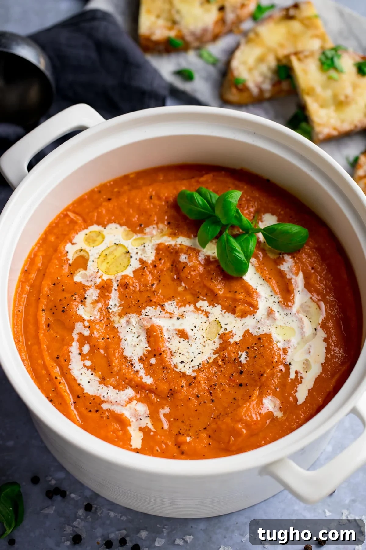 Creamy Homemade Tomato Soup Recipe 5 A pot of delicious tomato soup topped with double cream; and a plate of cheese toast on the side.