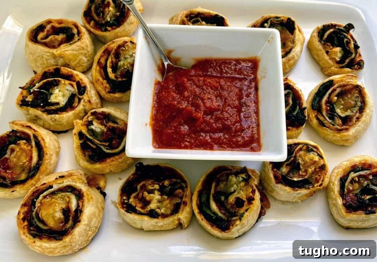 Vegan Pizza Pinwheels Recipe for Party Snacks 8 Vegan pizza pinwheel recipe on a plate served with extra pizza sauce.