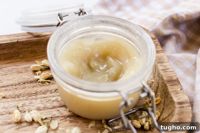 A jar of curl enhancing cream on a wooden tray.