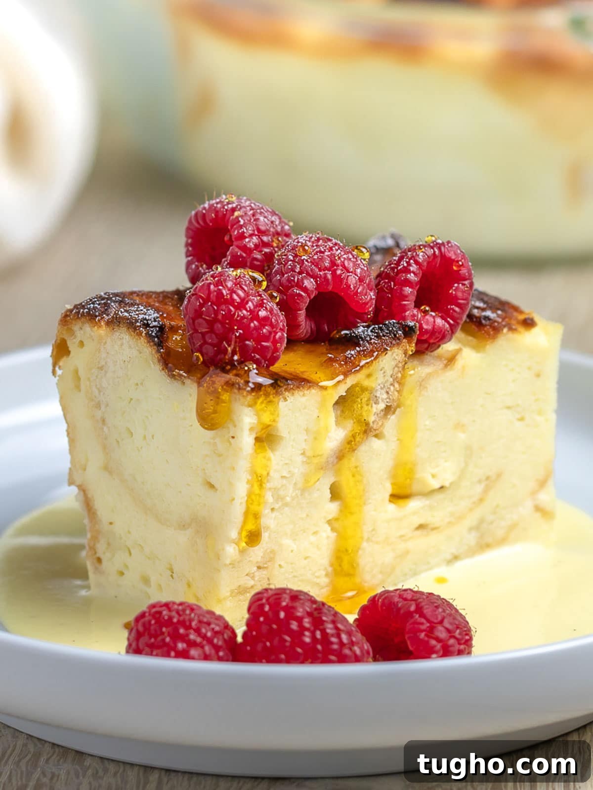 Custard bread pudding with raspberries and caramel syrup.