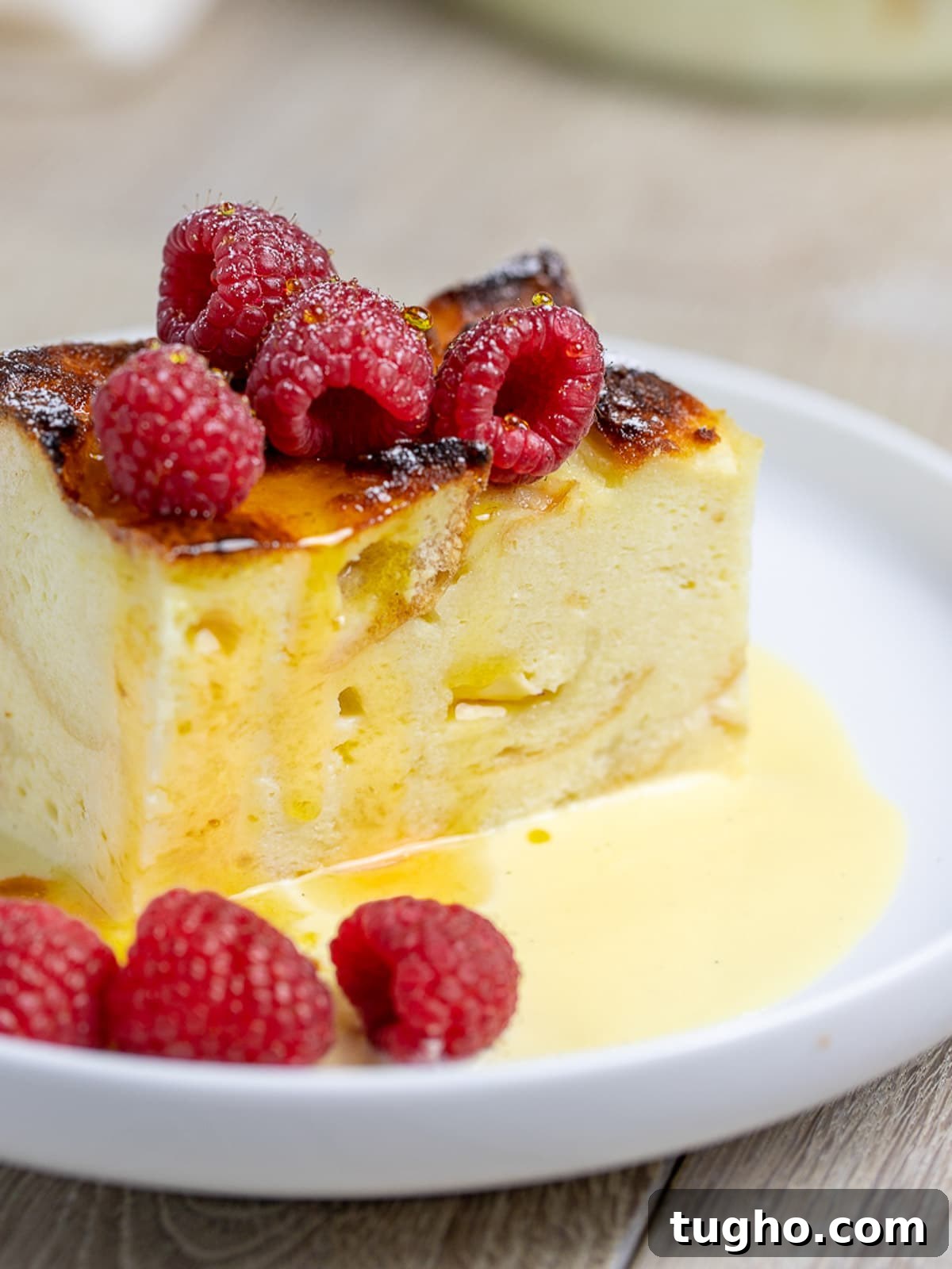 Bread pudding with vanilla sauce and raspberries.