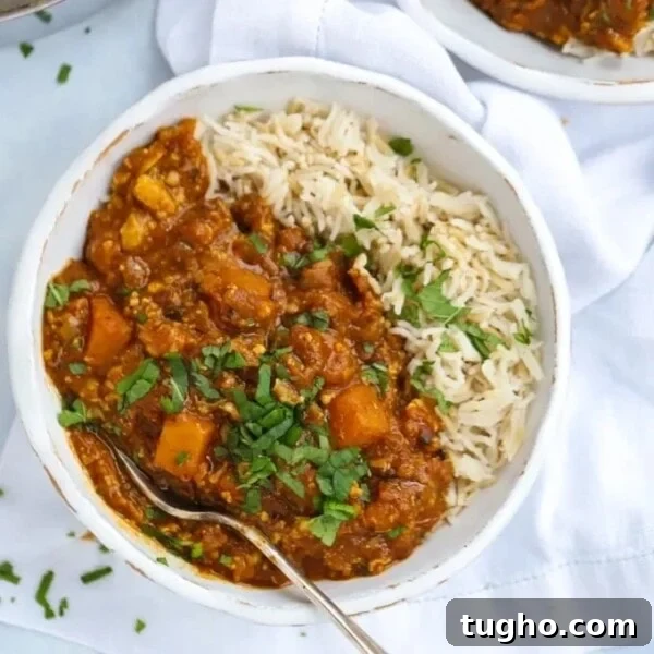 Slow Cooker Chana Saag: Chickpea Curry with Spinach 9 A bowl with butternut squash curry with rice and a fork ready to eat.