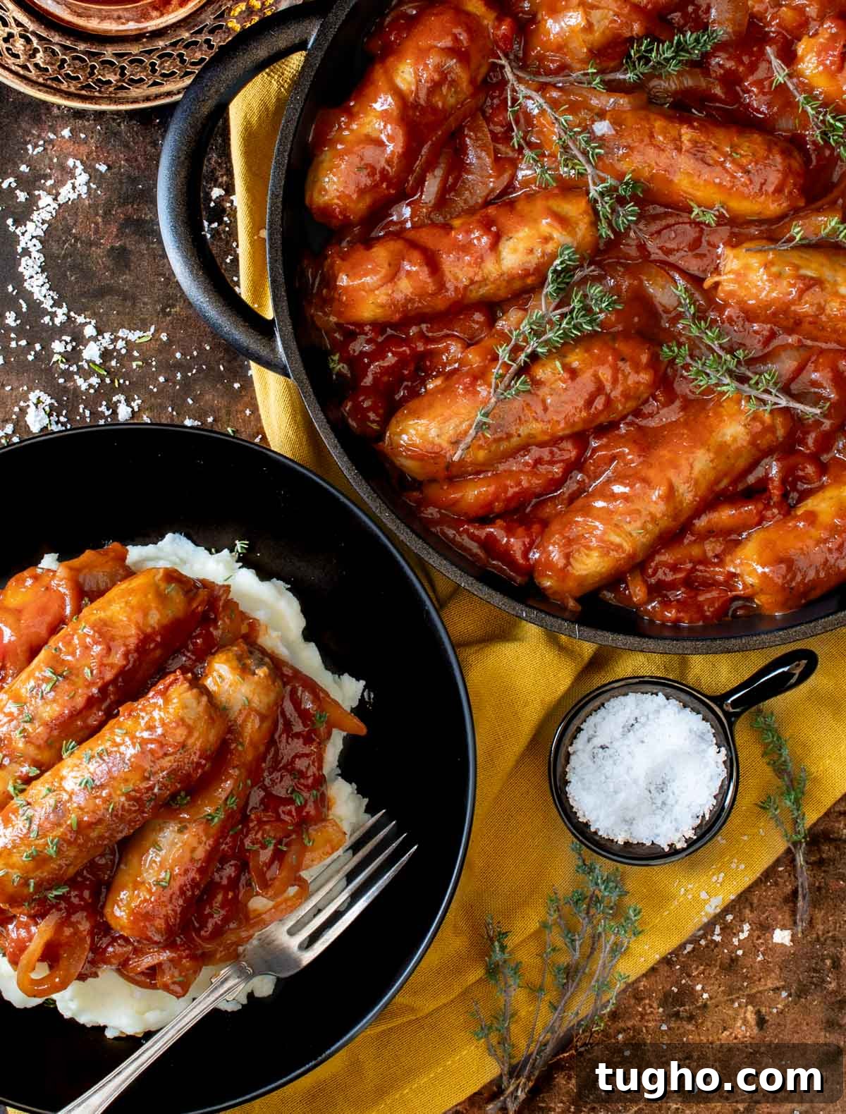 Devilled Sausages Recipe with Tangy Tomato Glaze 2 Devilled sausages in a pan with a bowl of devilled sausages and mash.