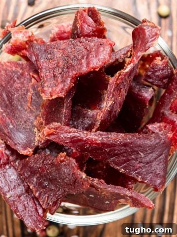 Beef jerky in a glass bowl on wood background