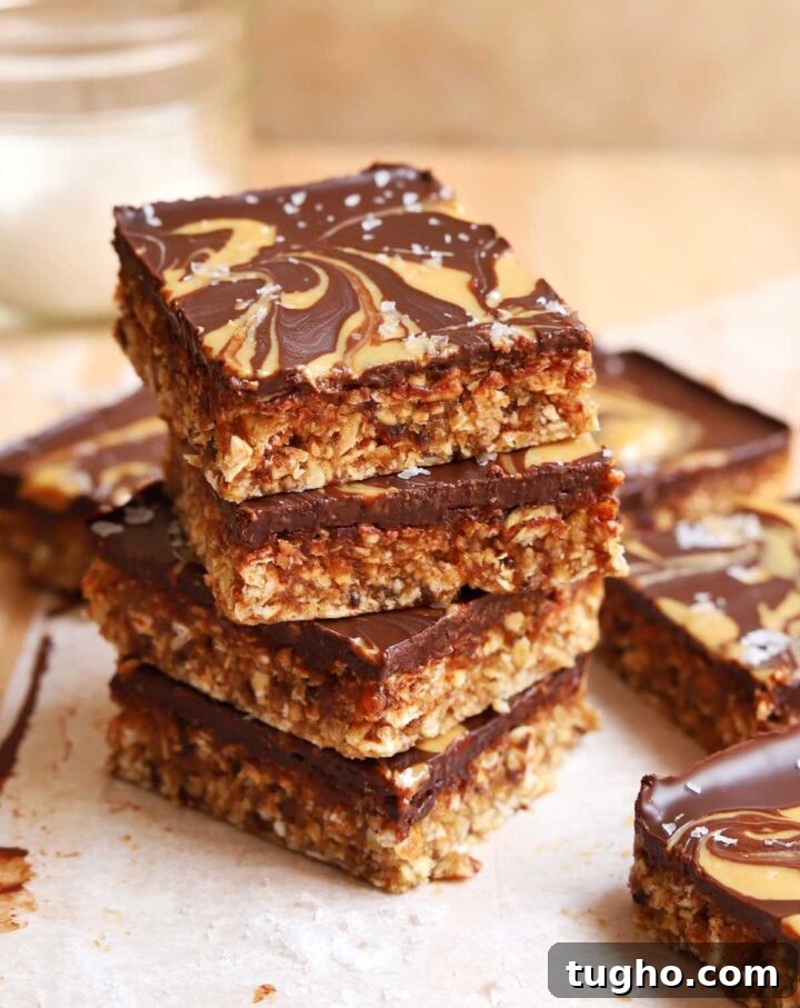 no bake chocolate tahini date oat bars stacked on cutting board