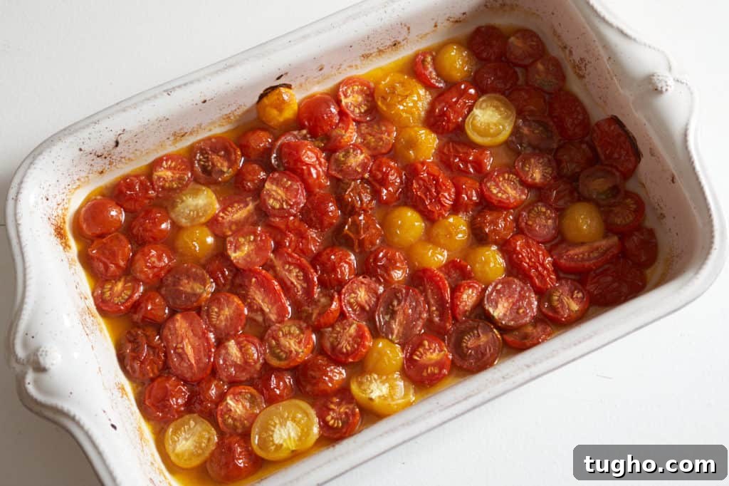 Roasted cherry tomatoes in a white casserole dish.