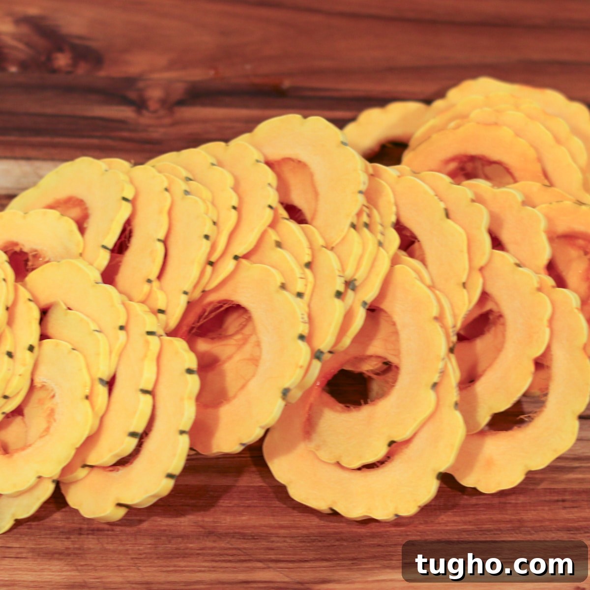 Delicata squash sliced and arranged evenly in a baking dish for even cooking.