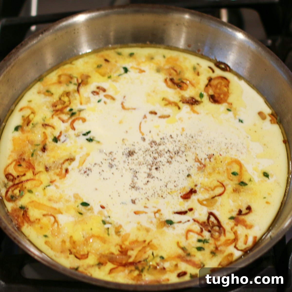 Heavy cream added to a pan over medium-low heat, being stirred and gently simmered until slightly thickened.