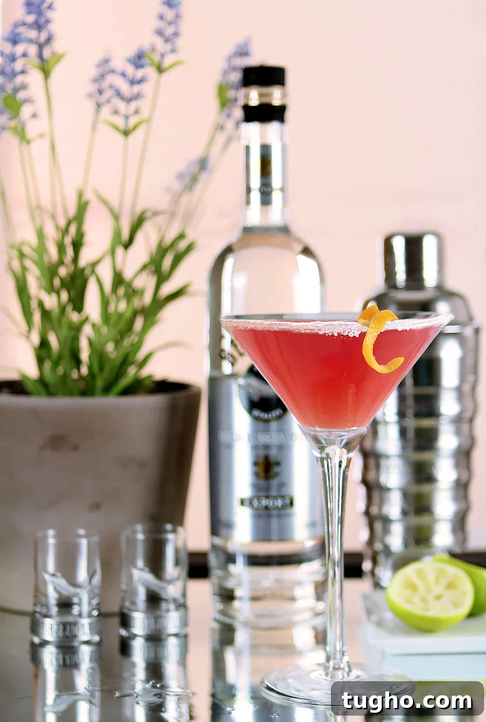 Classic Cosmopolitan Cocktail Recipe 3 Cosmopolitan Cocktail in Front of Vodka Bottle and Silver Shaker