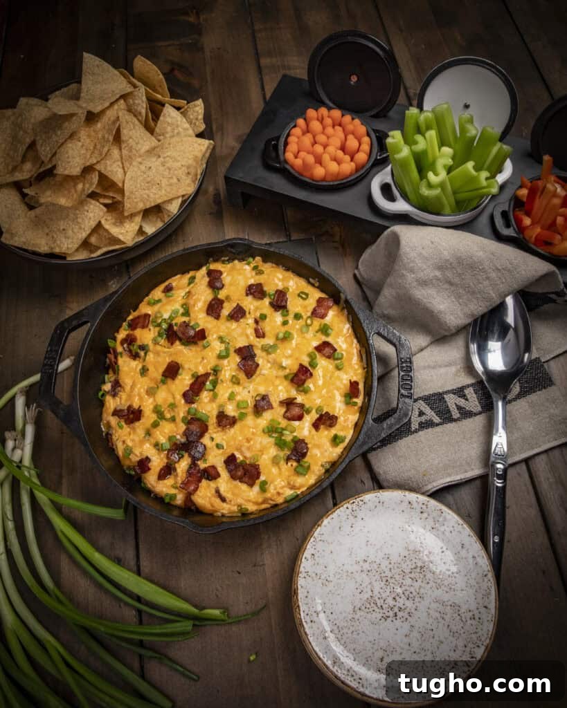 Hot buffalo chicken dip topped with bacon and green onions