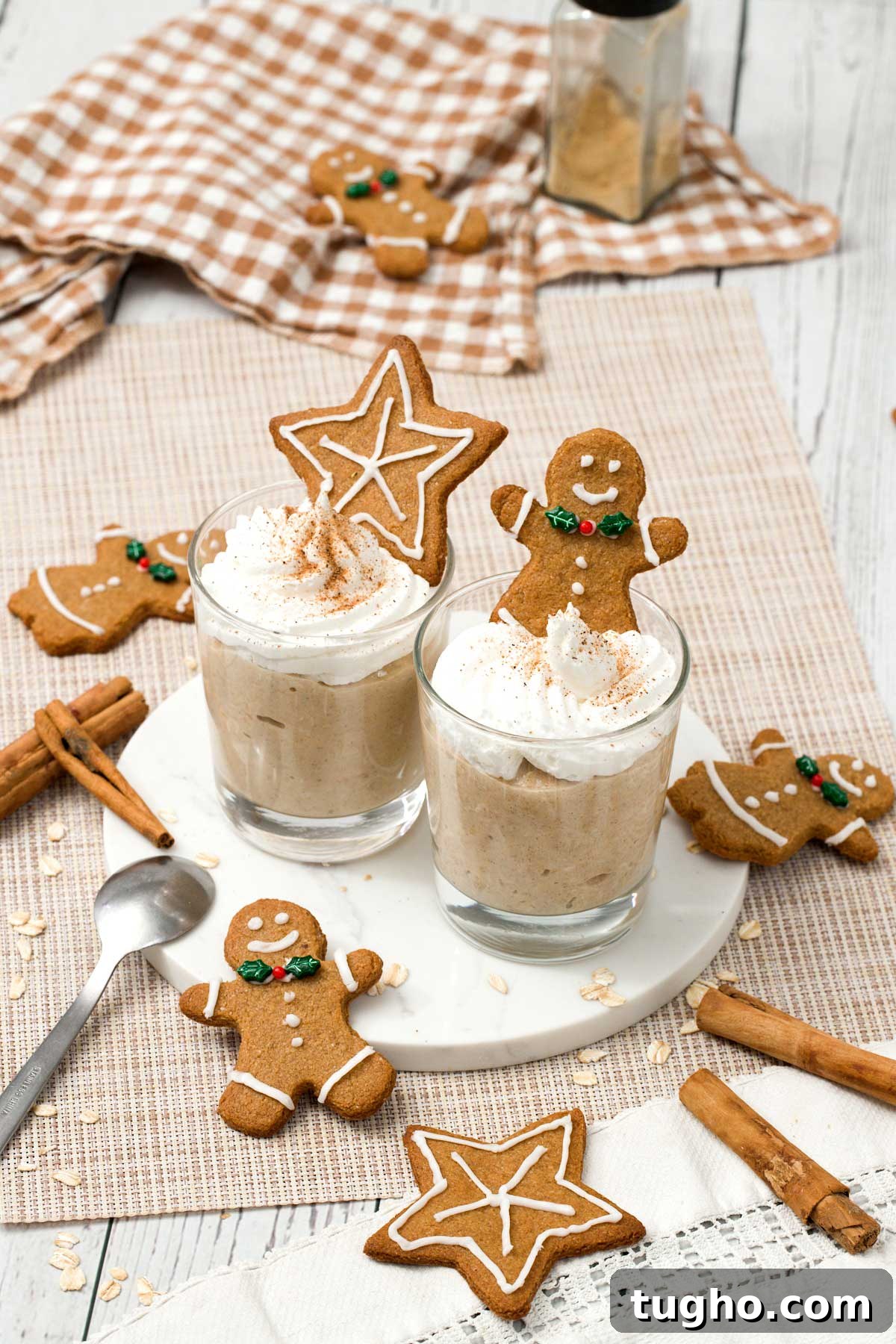 Gingerbread Overnight Oats with High-Protein Greek Yogurt 3 Two glasses of gingerbread overnight oats with a star and gingerbread man cookies on top.