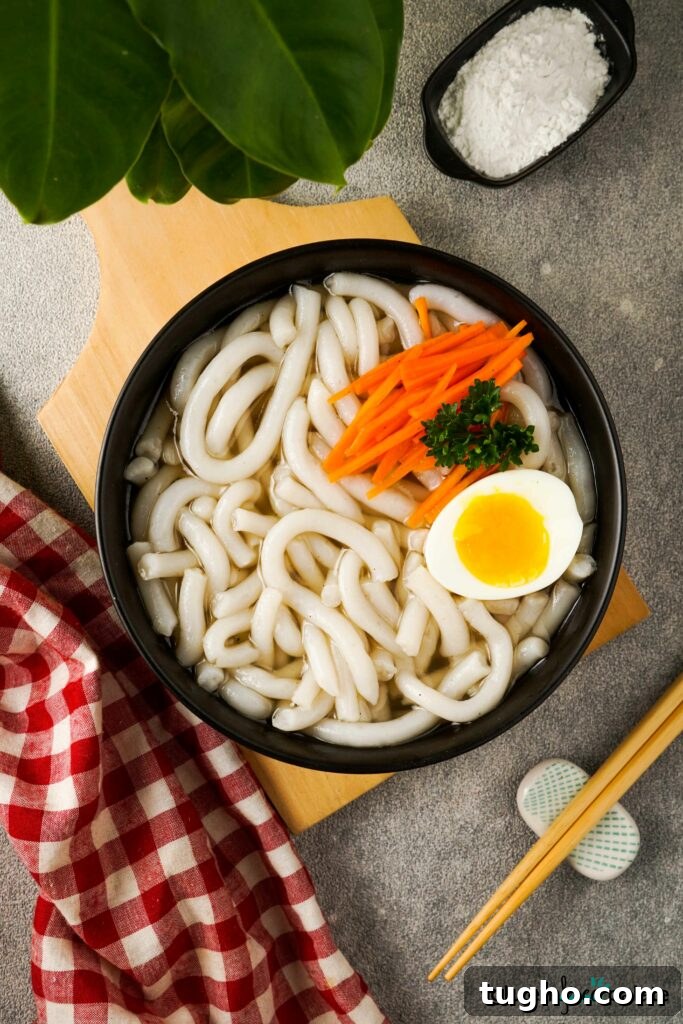 Gluten-Free Udon Noodles in a black bowl with chopsticks.