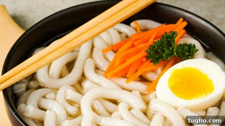 Gluten-Free Udon Noodles in a black bowl with chopsticks.