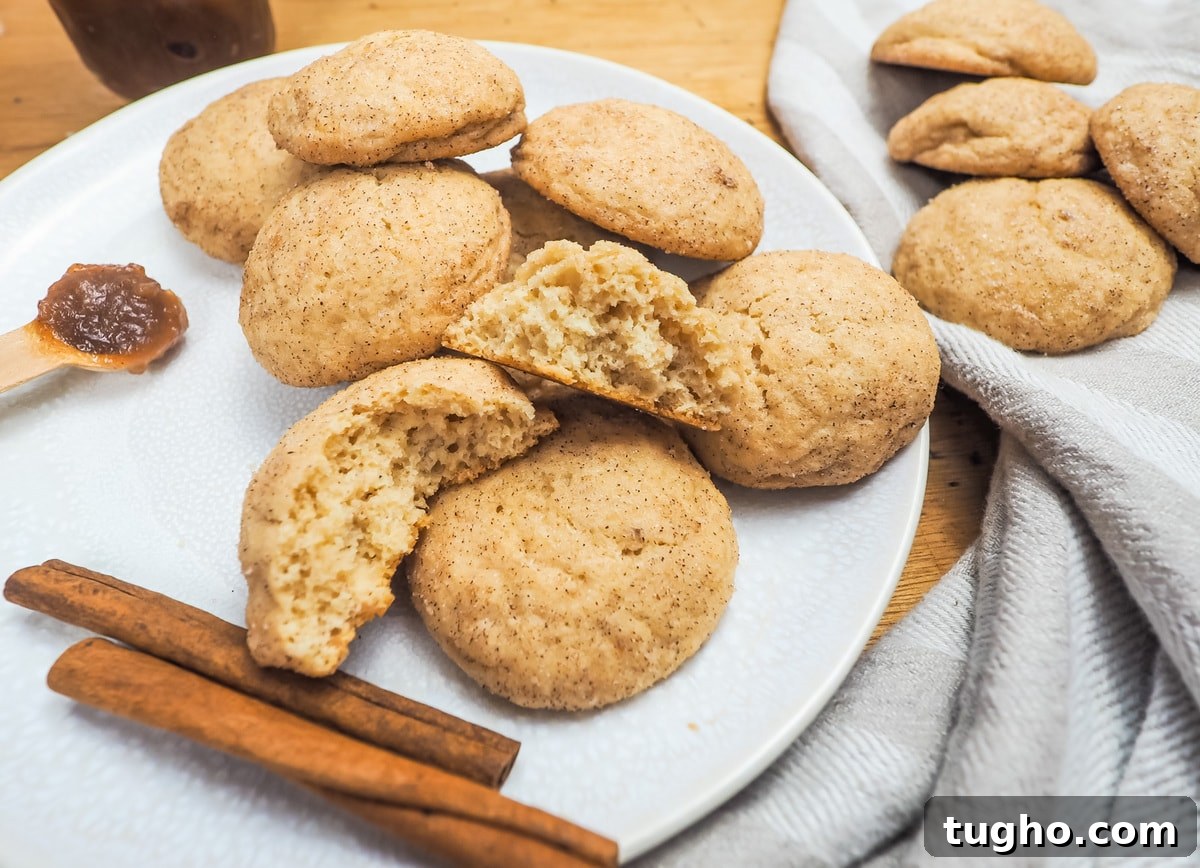 Apple Butter Snickerdoodle Cookies 12 A plate of snickerdoodles with two cinnamon sticks and one broken in half on the top of the pile.