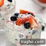 Patriotic Red, White and Blue Cheesecake Salad Recipe 8 Red, white, and blue cheesecake salad served in small dish.