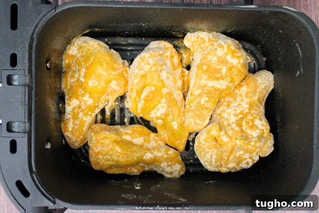 place hooters wings in air fryer basket then spritz with oil