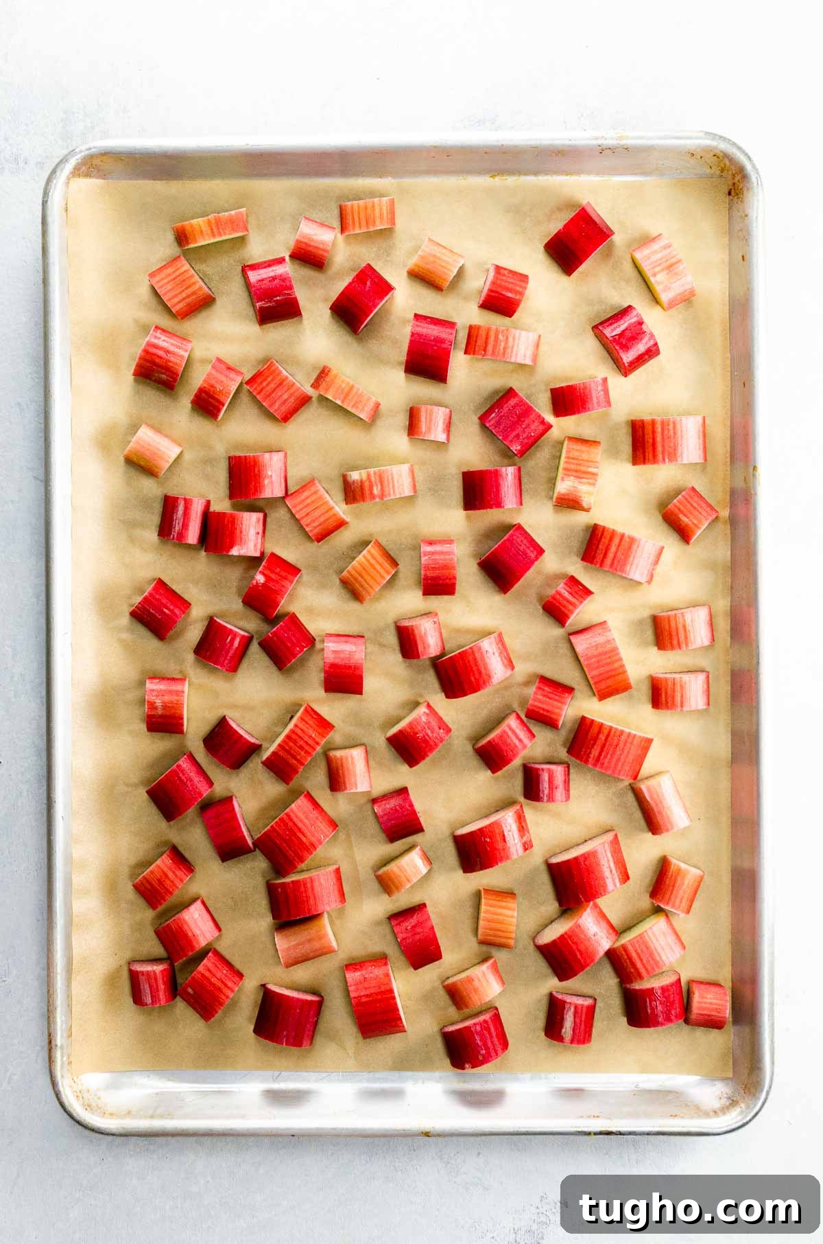 How to Freeze Rhubarb: Step-by-Step Storage Tips 2 rhubarb slices on a parchment-lined, rimmed baking sheet