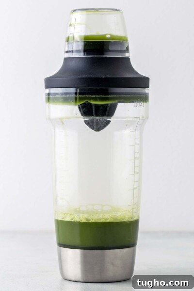 Layered Matcha Lemonade Recipe: Iced Citrus Green Tea 6 Water and matcha in a cocktail shaker with the lid on.