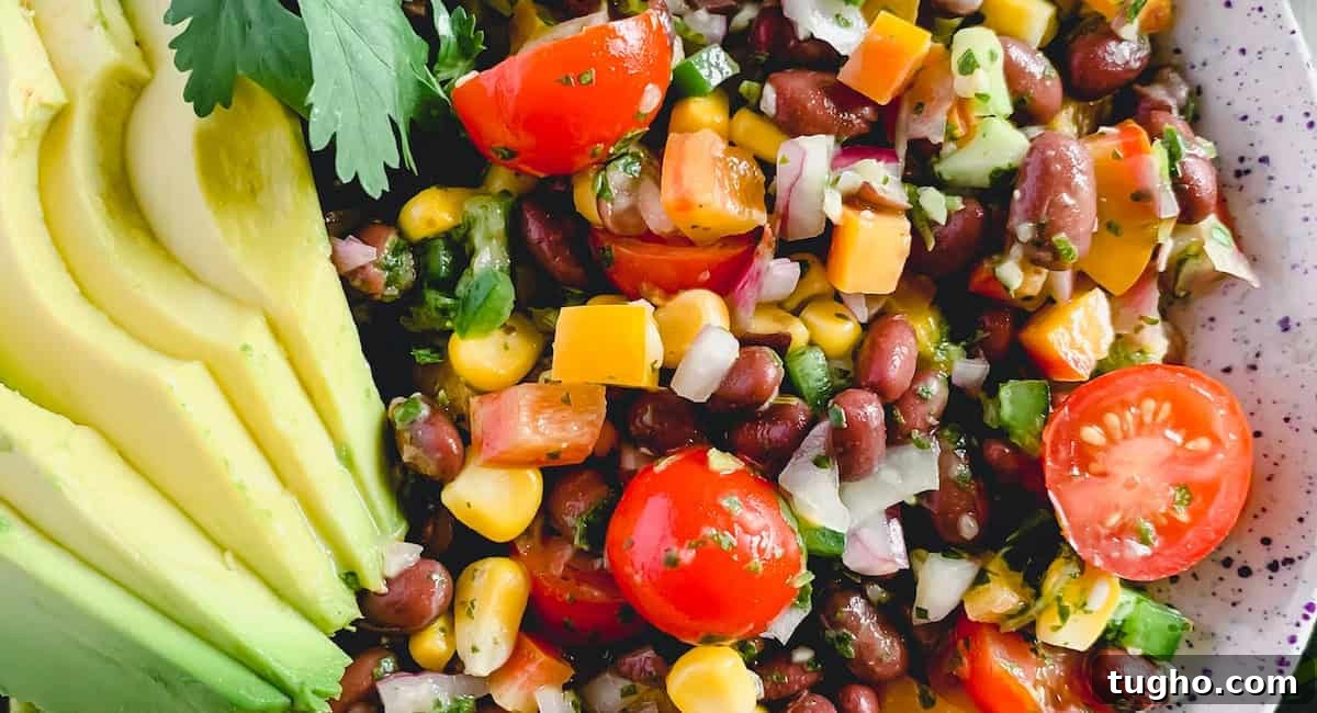 Overhead up close image of fiesta salad with avocado slices as garnish. 