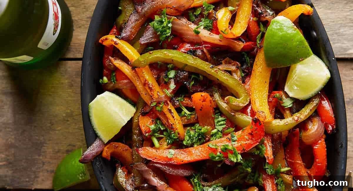Overhead image of grilled peppers and onions with lime wedge garnish. 