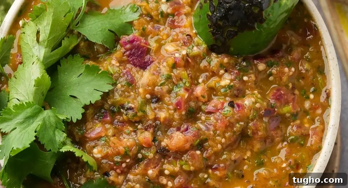 Overhead image of salsa verde (smoky roasted romatillo sauce) with garnish. 